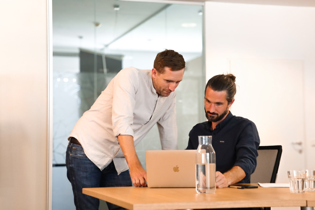 Philipp Elsler und Martin Trümmel von dreicraft vor einem Laptop im Büro